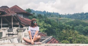 girl sitting on rooftop in bali. digital nomad living in bali. 5 jobs that allow you to travel the world. 5 fully nomadic careers that allow you to travel the world