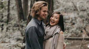 A man and woman stand gleefully in the forrest. They just sold everything they own and became minimalists, and they couldn't be happier.